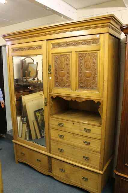 Appraisal: A VICTORIAN ASH WARDROBE enclosed by mirror panel door flanked