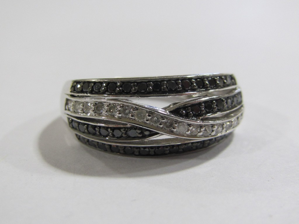 Appraisal: Nine carat white gold black and white diamond four row