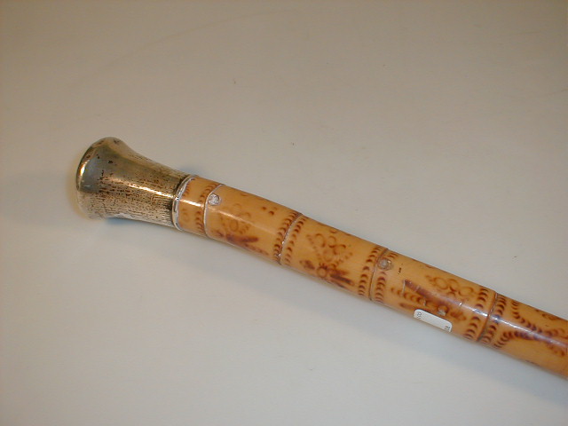 Appraisal: An antique silver capped poker work bamboo walking cane