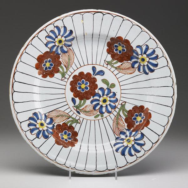 Appraisal: DELFT Polychrome charger with floral decoration th C Hairline dia