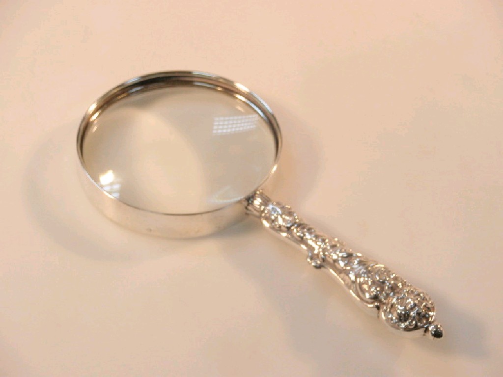 Appraisal: A late Victorian silver magnifying glass with an embossed handle