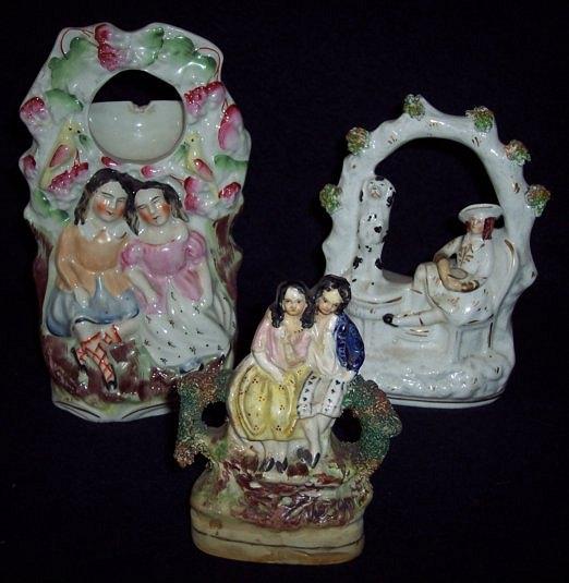 Appraisal: A Staffordshire watch stand with two figures beneath cm high