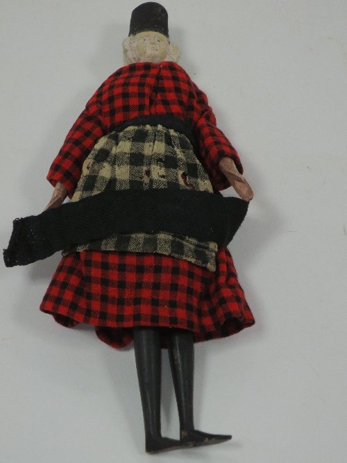 Appraisal: A Breton wooden doll with jointed limbs wearing traditional costume