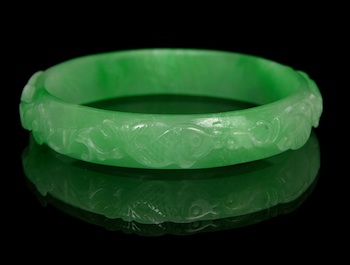 Appraisal: A Carved Jadeite Bangle with Fish and Ruyi Designs Chinese