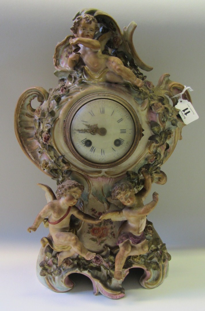 Appraisal: A Sitzendorf porcelain mantel clock th century moulded with cherubs