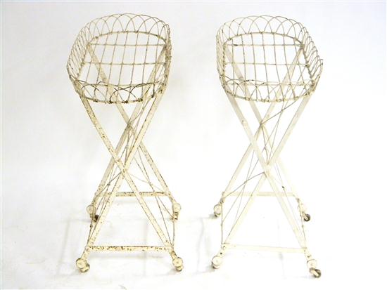 Appraisal: Two metal wire oval plant stands on wheels painted white