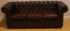 Appraisal: A red leather upholstered Chesterfield sofa with buttoned back by