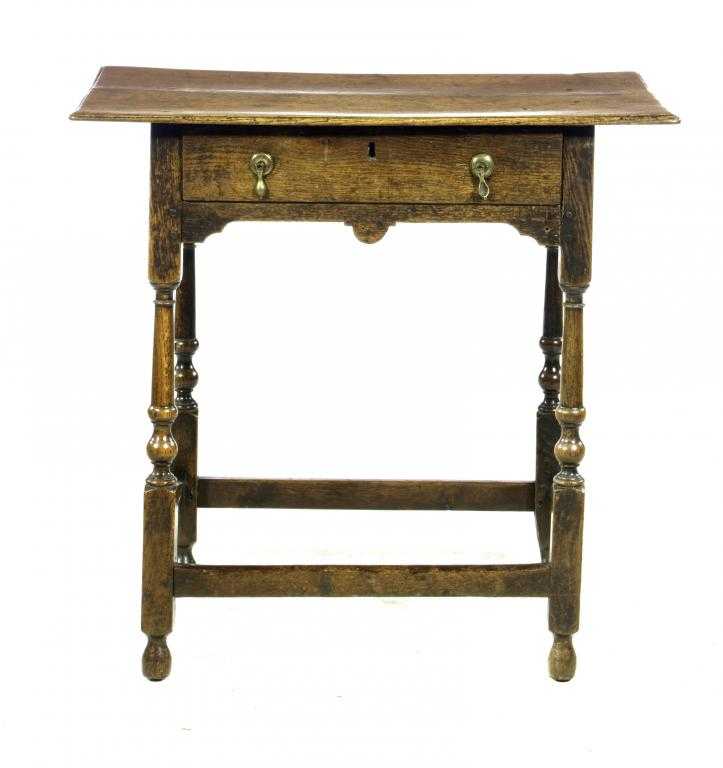 Appraisal: A GEORGE II OAK SIDE TABLE with oversailing boarded top