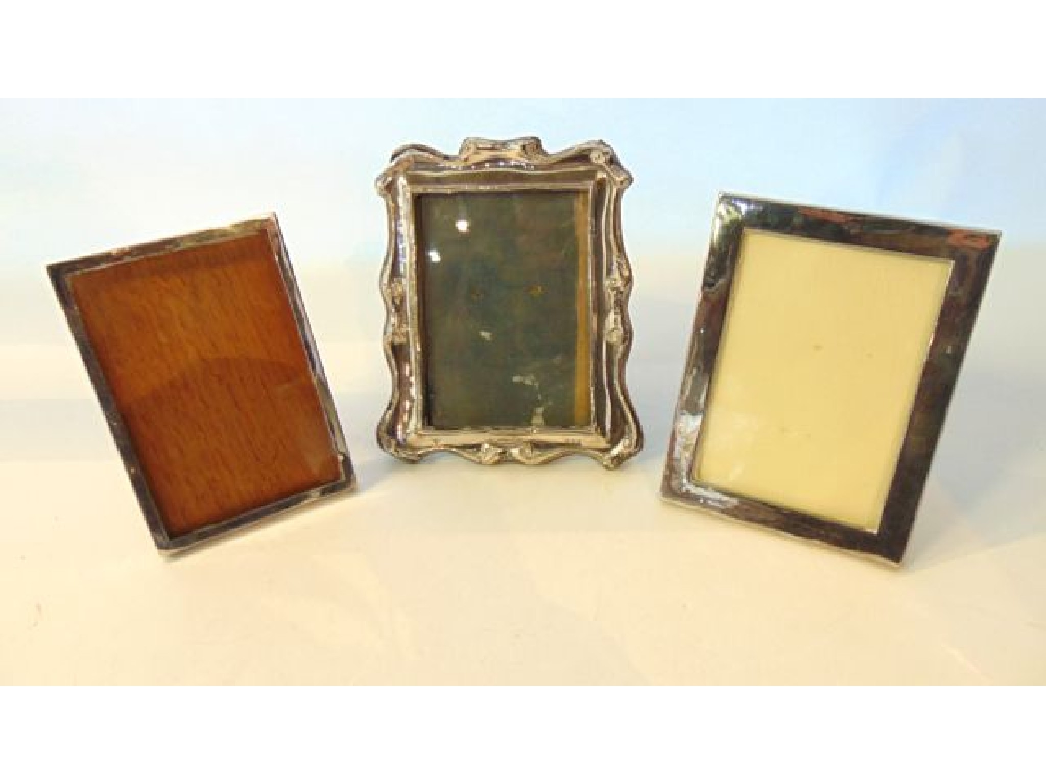 Appraisal: A miscellaneous collection of three easel back silver picture frames