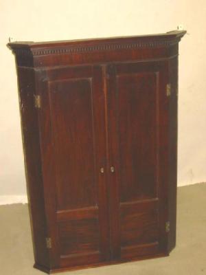 Appraisal: A GEORGE III MAHOGANY CORNER CUPBOARD with dentil moulded cornice