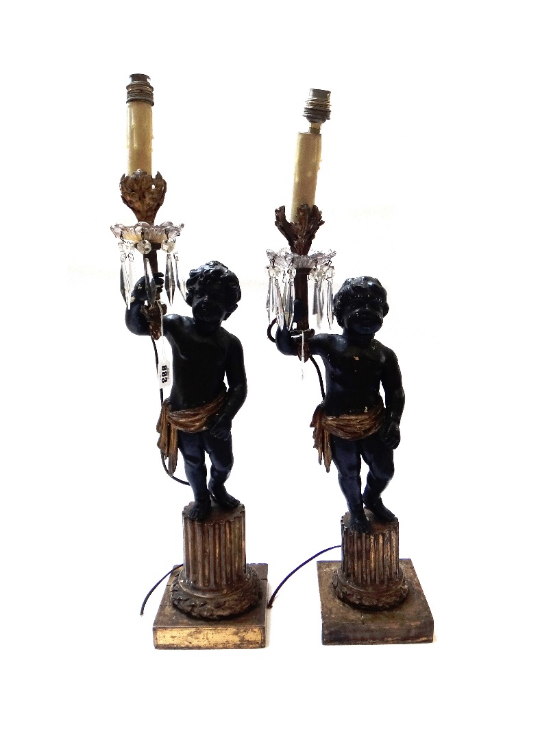 Appraisal: A pair of ebonised and giltwood figural table lamp lustres