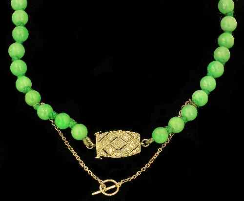 Appraisal: A Chinese stained jadeite single strand graduated bead necklace with