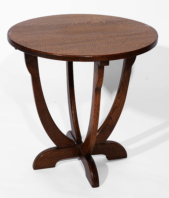 Appraisal: A Cotswold School oak circular occasional tablecirca with four inward