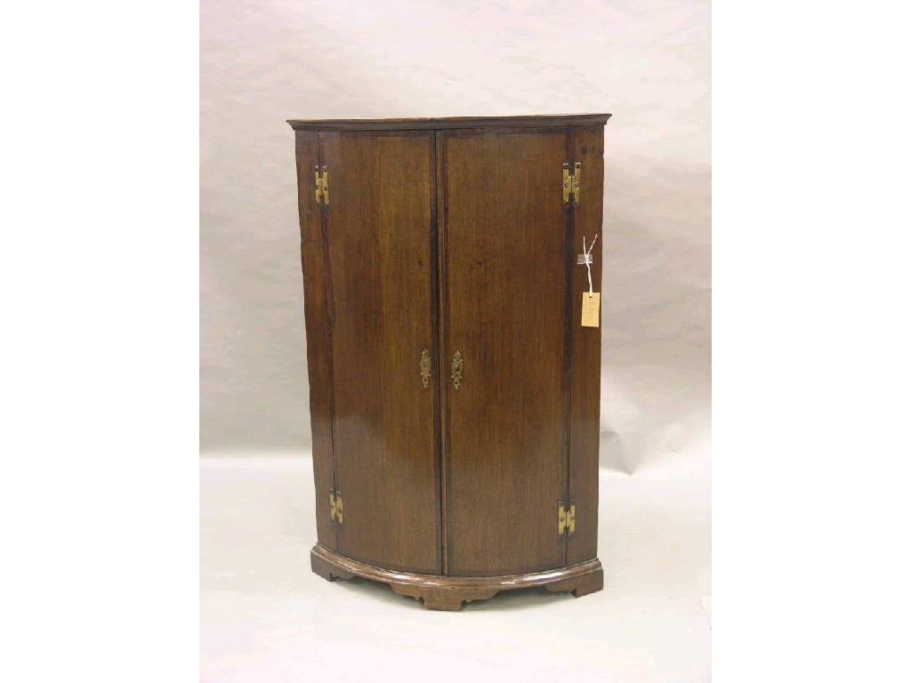 Appraisal: A late Georgian oak corner cupboard bowed front with mahogany