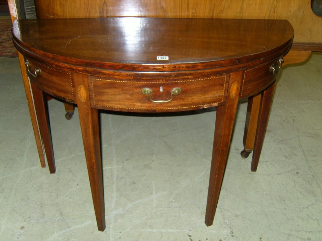 Appraisal: A Georgian mahogany demi lune fold over top card table