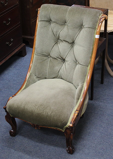 Appraisal: A VICTORIAN MAHOGANY BUTTON BACKED SLIPPER CHAIR with scroll carved