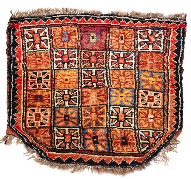 Appraisal: A QUCHAN SADDLE RUG shield shaped with polychrome panel decoration