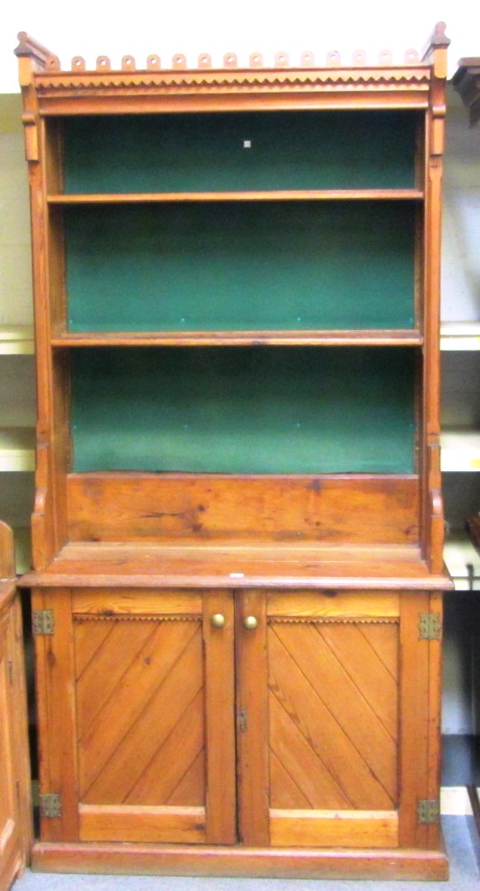 Appraisal: A Victorian Gothic revival pitch pine bookcase cupboard with castellated