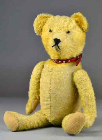 Appraisal: Antique English Teddy BearAntique teddy bear of yellow mohair center