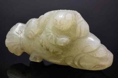 Appraisal: A Chinese pale green jade carving of a boy and