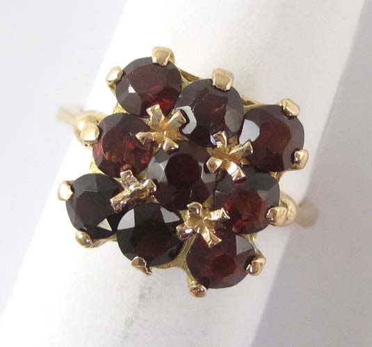 Appraisal: GARNET AND EIGHTEEN KARAT GOLD RING set with six round-cut