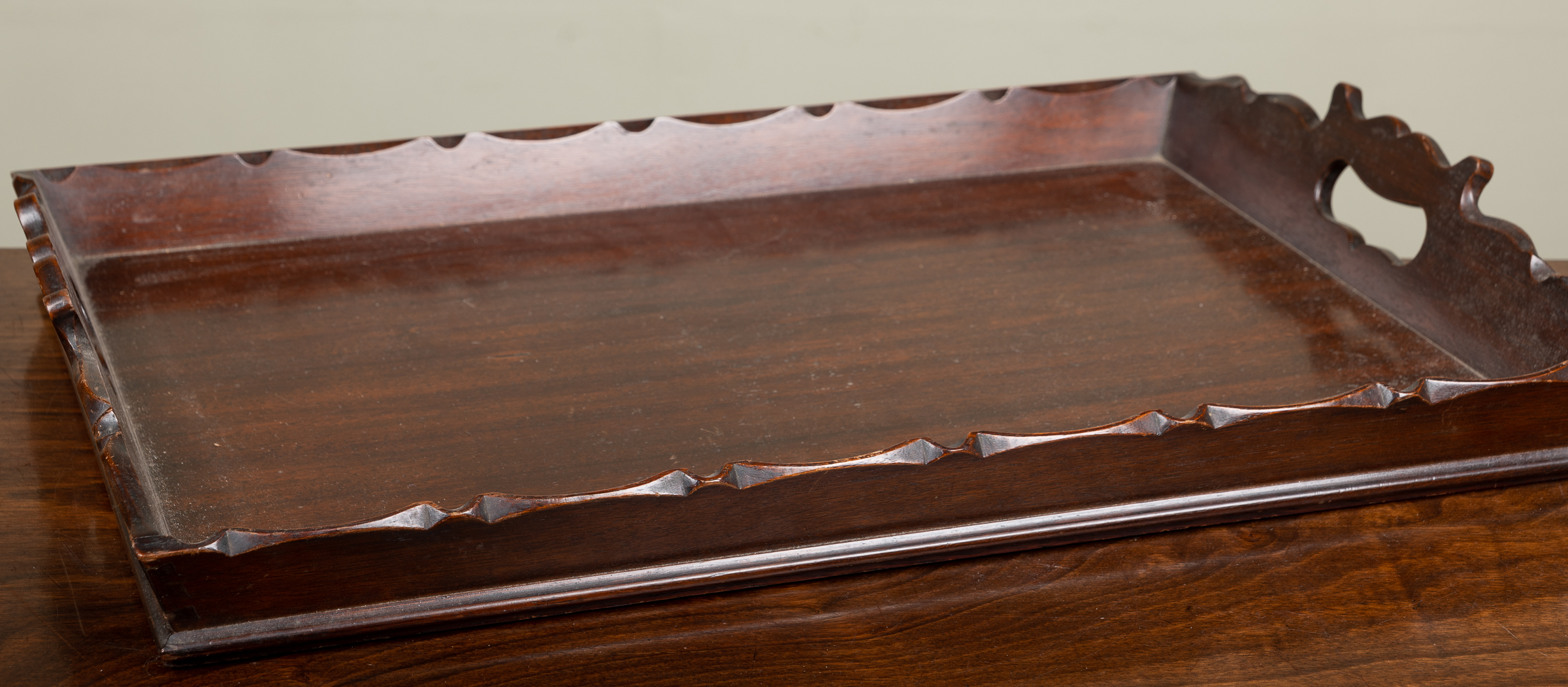 Appraisal: A Georgian-style rectangular mahogany tray with pierced carrying handles to