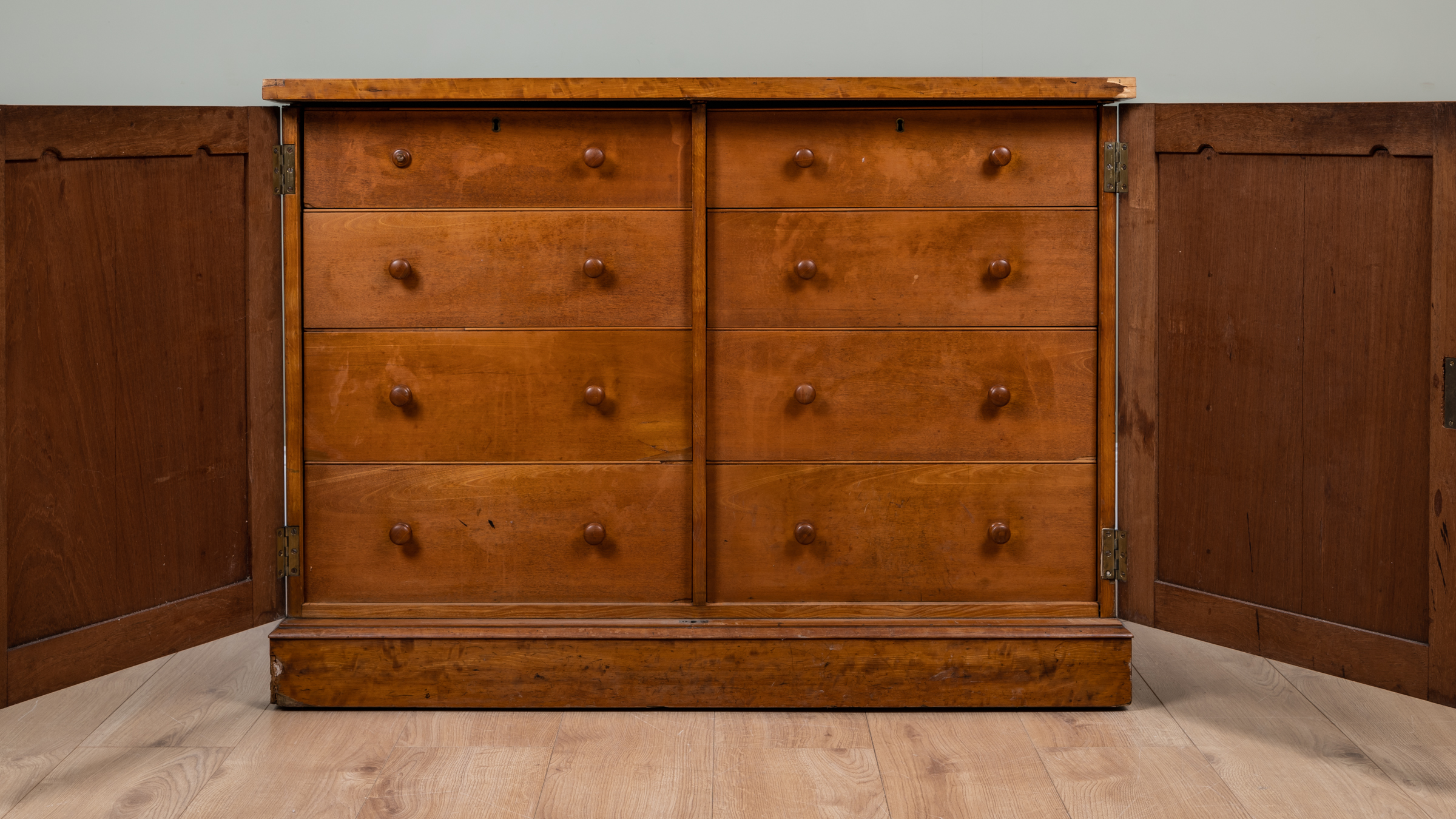 Appraisal: A satinwood library cabinet the panelled doors with carved ornament