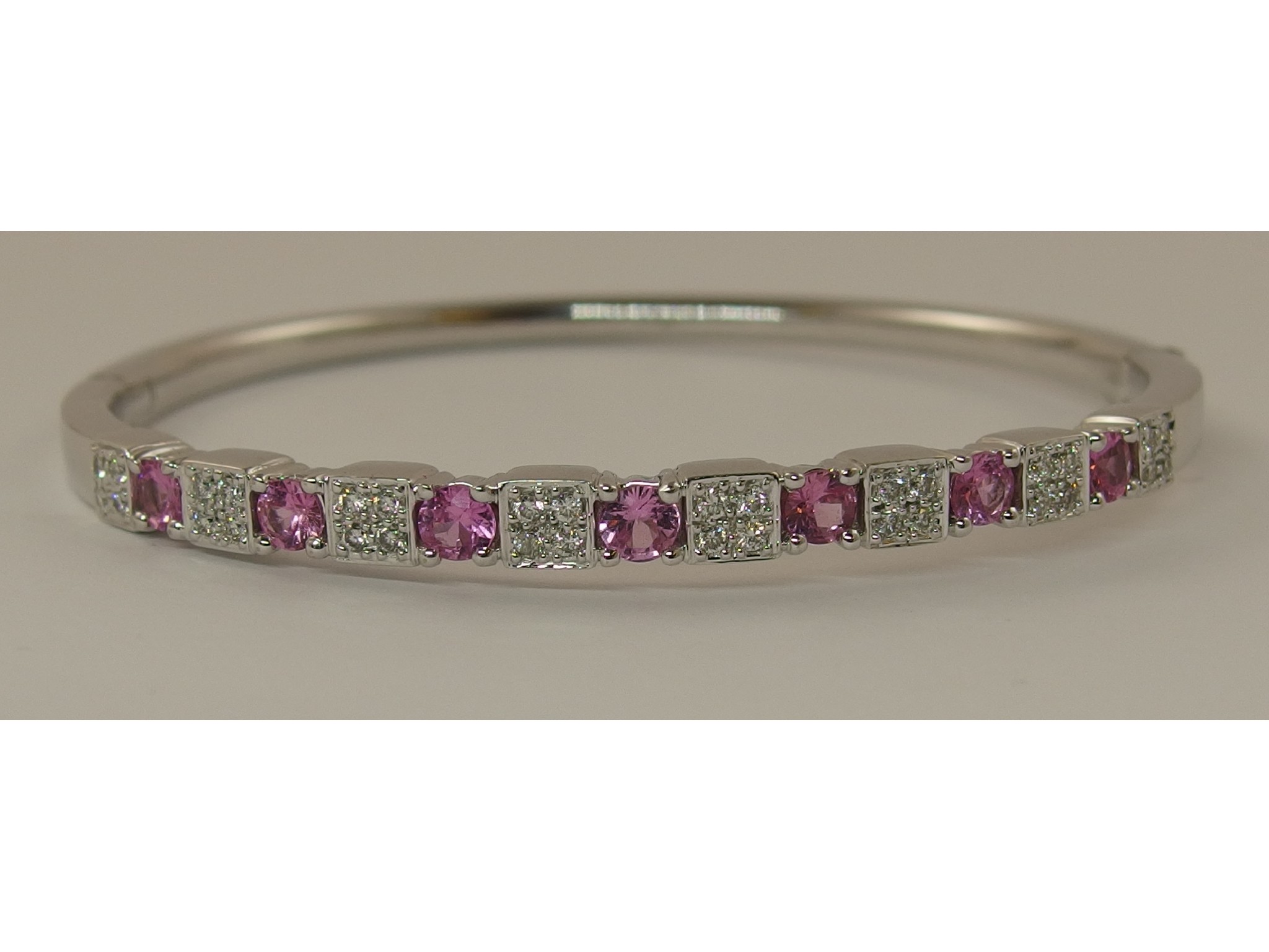 Appraisal: An ct white gold pink sapphire and diamond banglethe seven