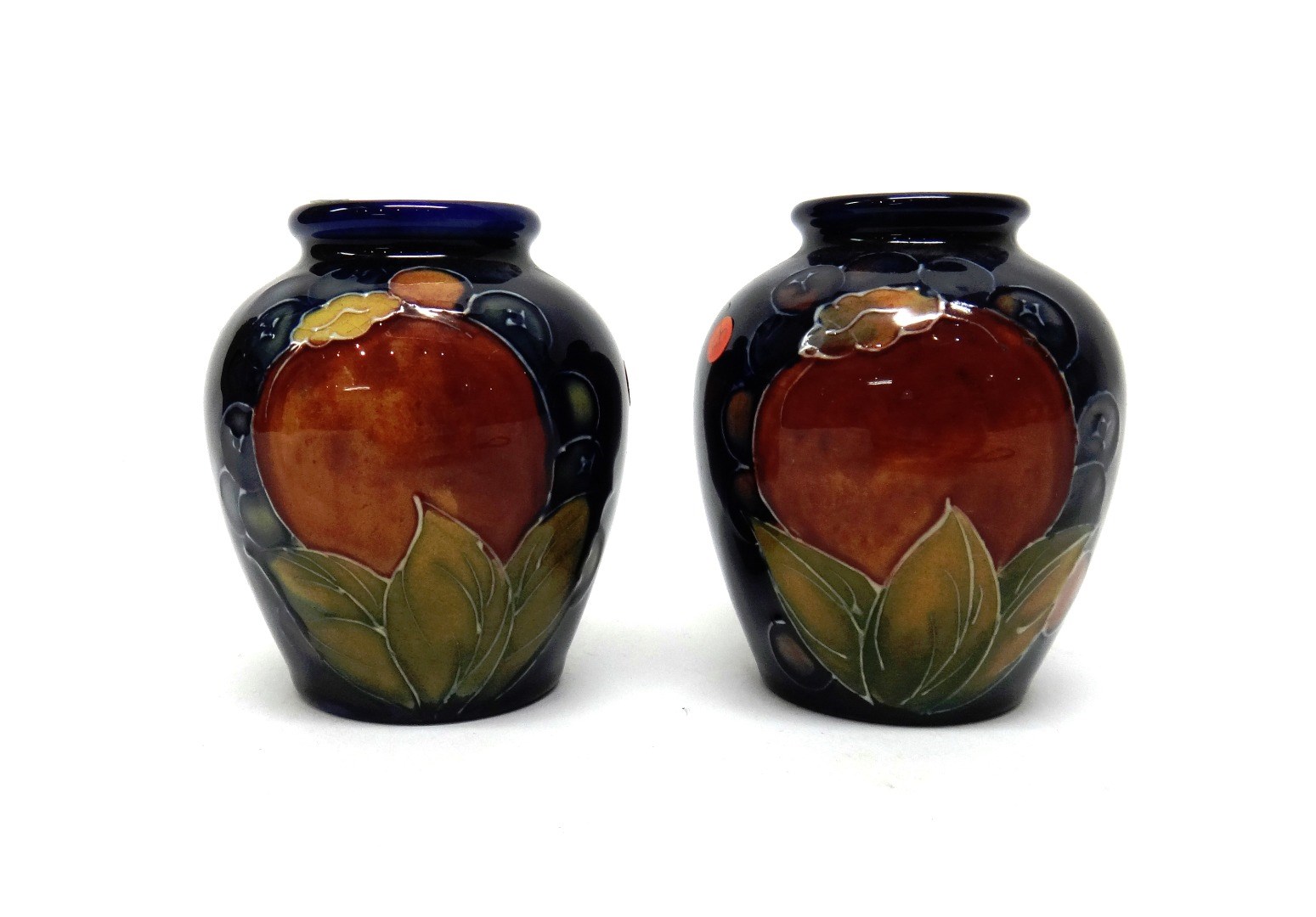 Appraisal: A pair of small Moorcroft 'Pomegranate' blue ground vases circa