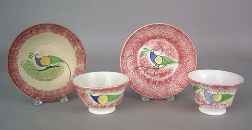 Appraisal: Two red spatter cups and saucers th c with peafowl