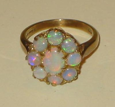 Appraisal: AN OPAL CLUSTER RING modelled as a flowerhead claw set