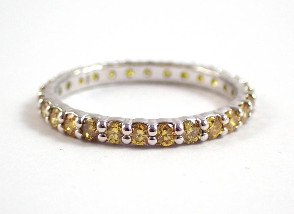 Appraisal: YELLOW DIAMONDS AND FOURTEEN KARAT WHITE GOLD ETERNITY RING rimmed