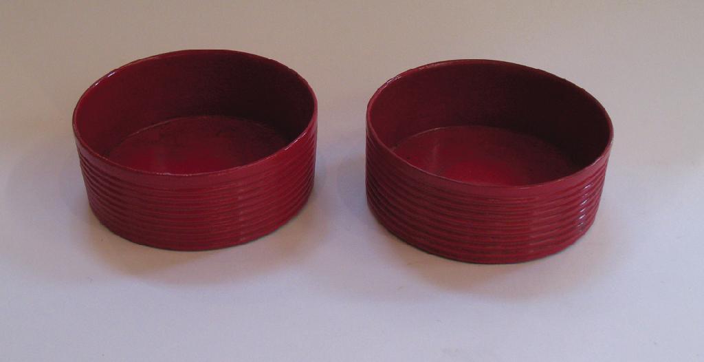 Appraisal: A PAIR OF REGENCY RED LACQUERED BOTTLE COASTERS with ringed