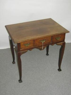 Appraisal: A GEORGE III OAK LOWBOY the moulded edged top over