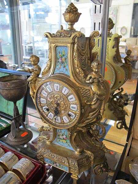 Appraisal: FRENCH BRASS PUTTO ADORNED MANTEL CLOCK WITH KEY