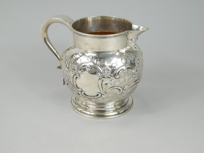 Appraisal: A late Victorian silver jug embossed with scrolls flowers etc