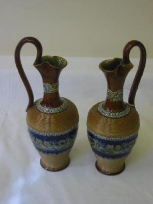 Appraisal: A PAIR OF DOULTON LAMBETH STONEWARE EWERS of baluster form