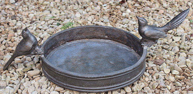 Appraisal: A CAST CIRCULAR SHALLOW LEAD BIRDBATH mounted by two cast