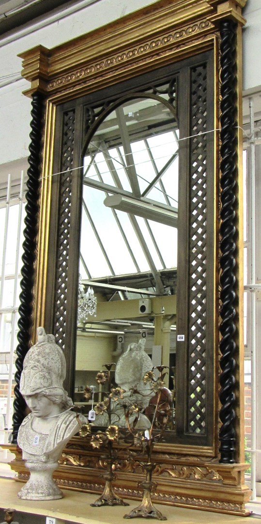 Appraisal: An ebonised and parcel gilt wall mirror with lattice work