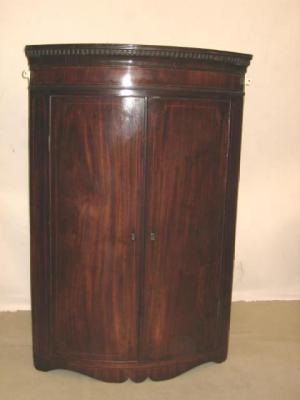 Appraisal: A GEORGE III MAHOGANY CORNER CUPBOARD of quadrant form with