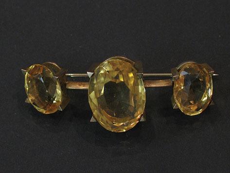 Appraisal: A THREE STONE CITRINE BAR BROOCH the central cushion-cut citrine