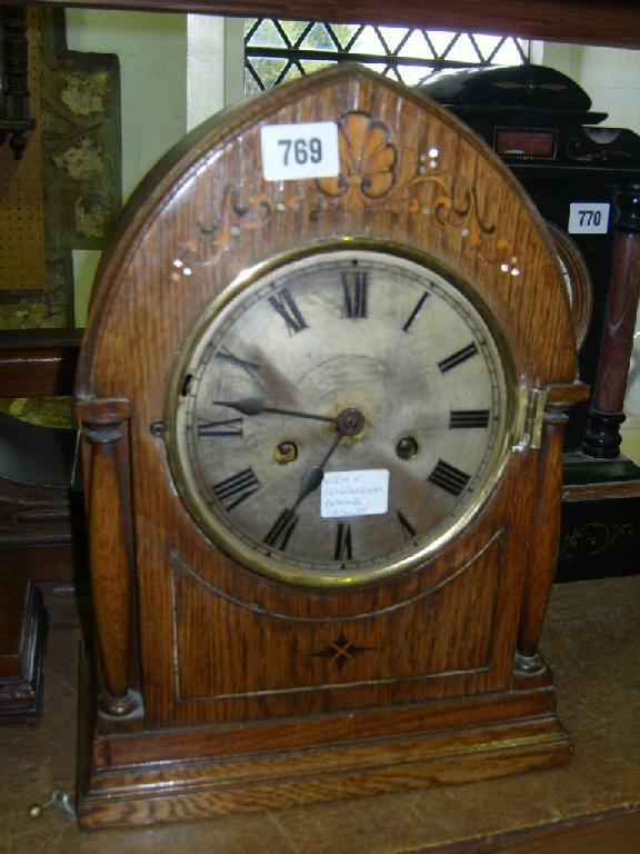 Appraisal: A substantial Edwardian oak lancet shaped mantle clock with inlaid