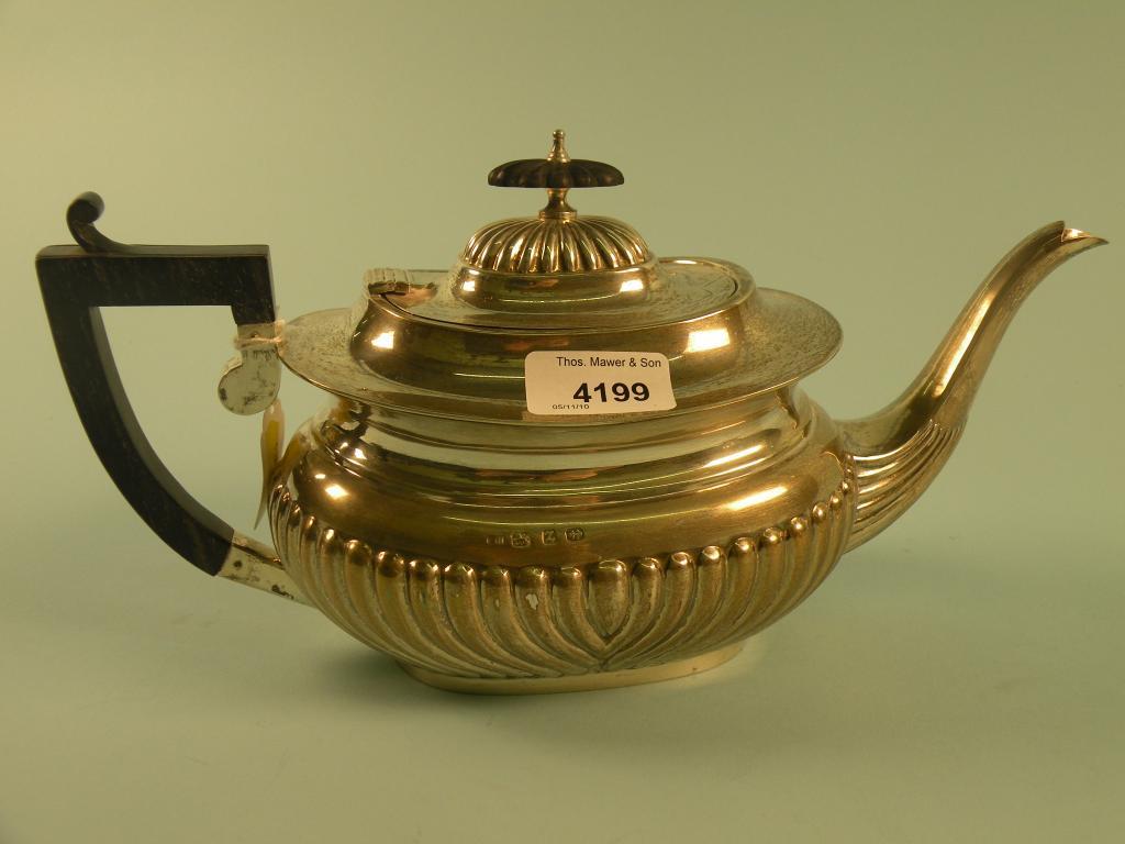 Appraisal: A part fluted silver teapot with ebonised handle and knop