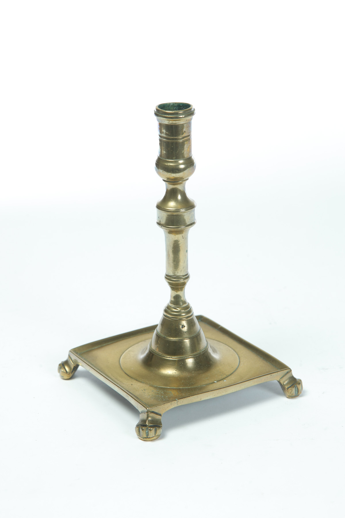 Appraisal: BRASS SPANISH CANDLESTICK Mid th century Square base with paw