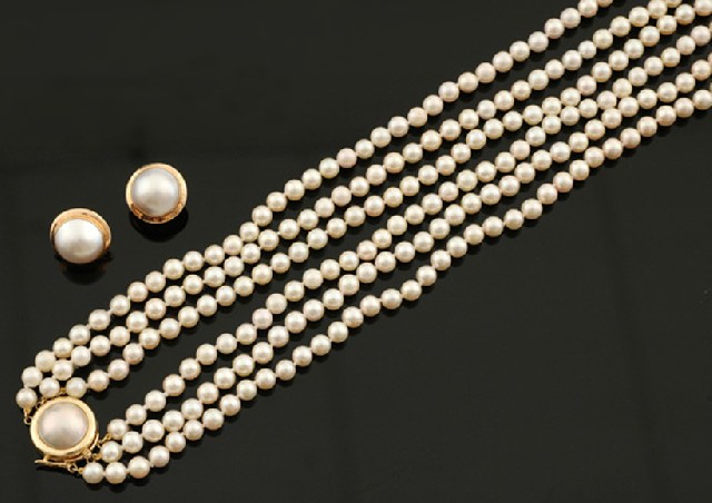 Appraisal: A triple strand cultured pearl necklace with a pair of