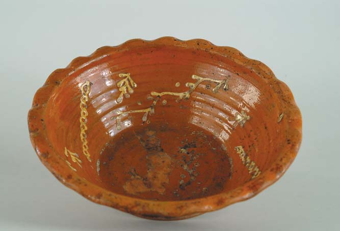 Appraisal: SLIP DECORATED REDWARE BOWL Sloped sides with pinched scalloped rim