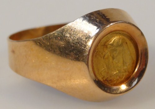 Appraisal: A dress ring with Madonna centre on plain shank yellow