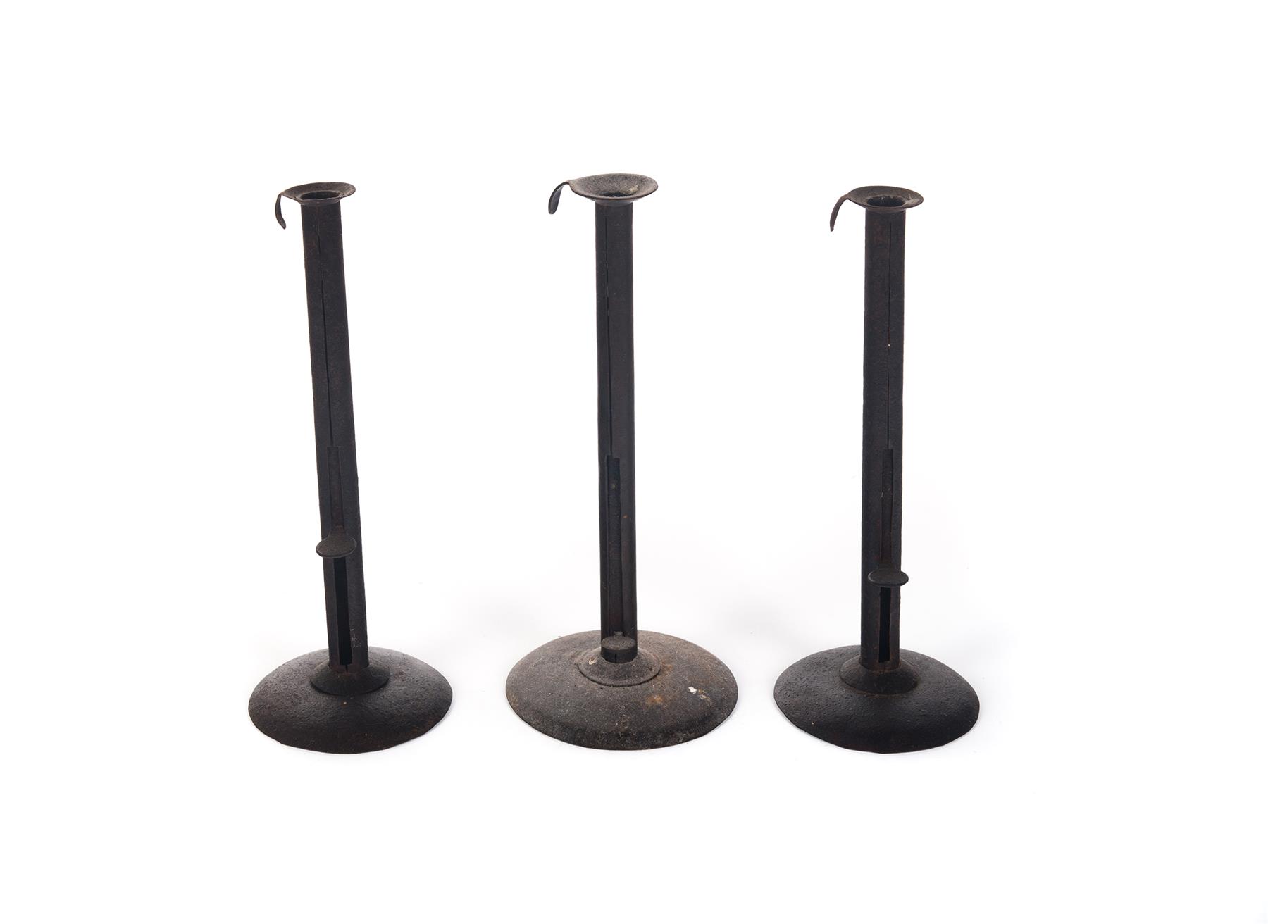 Appraisal: THREE HOGSCRAPER CANDLESTICKS Probably American th century Tall candlesticks with