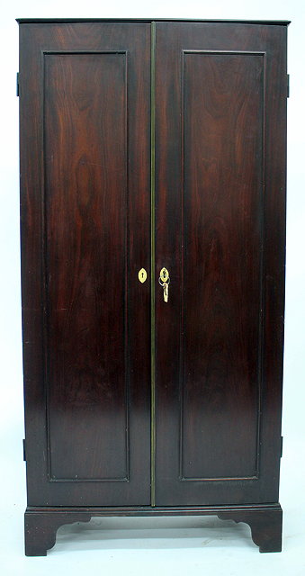 Appraisal: A GEORGE III MAHOGANY ESTATE CUPBOARD with twin panelled doors