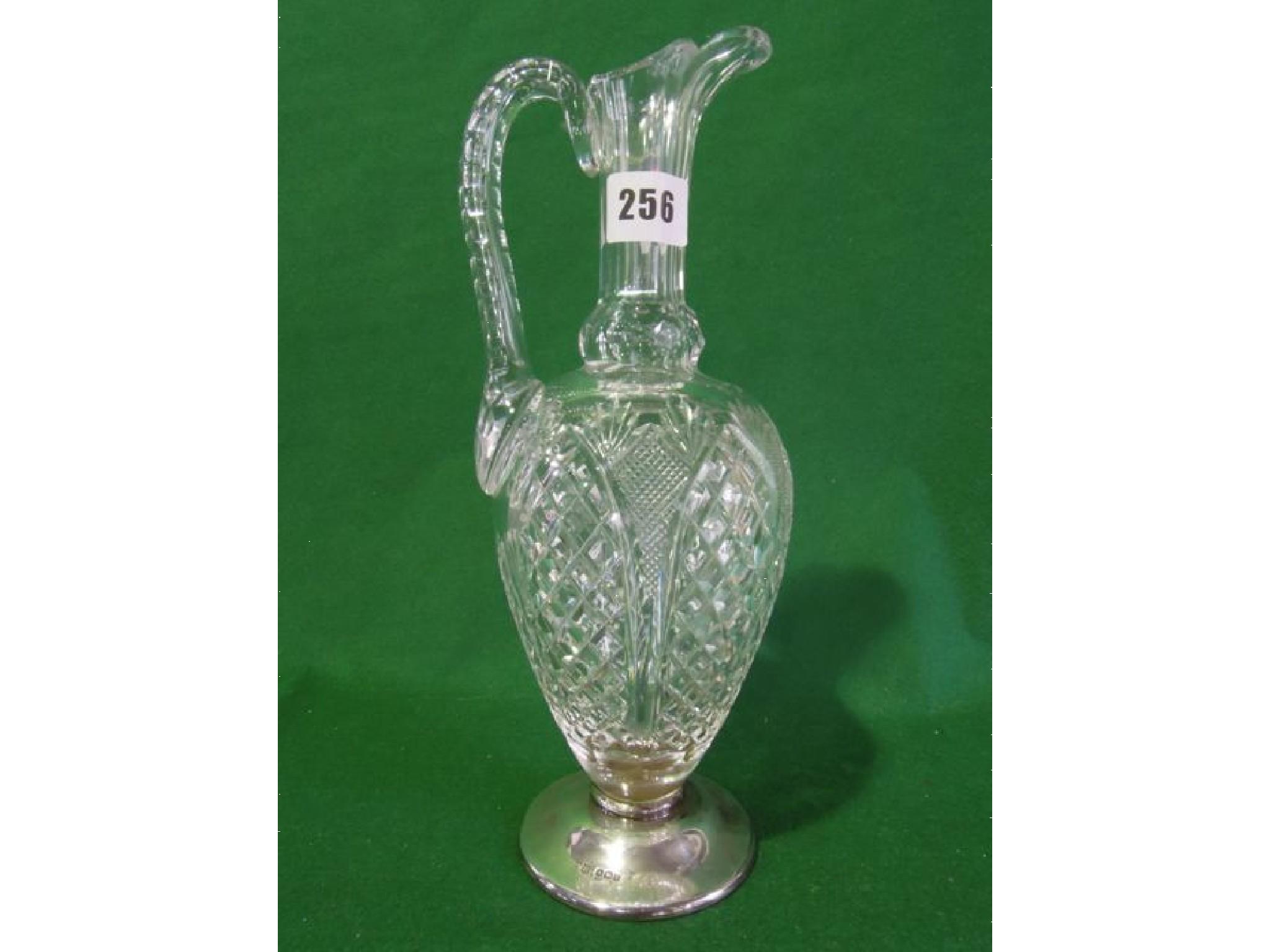 Appraisal: A well cut crystal decanter with a silver capped base